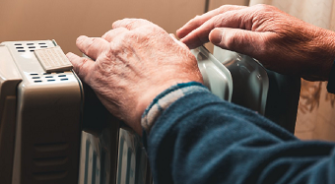 An old man touching his heater