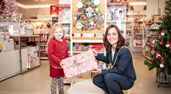 A woman giving a present to a small girl