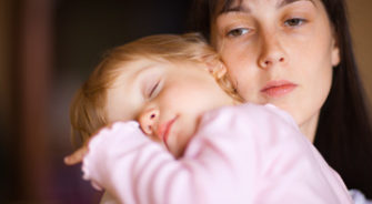 A mother holding her sleepy daughter