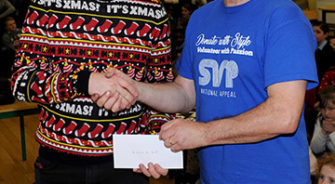 A man receiving a cheque by an SVP member