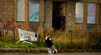 A kid playing football alone