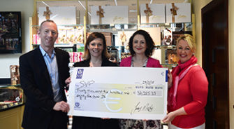 People holding a cheque inside a Butler's chocolate shop