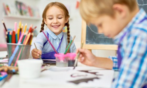 Two kids painting in school