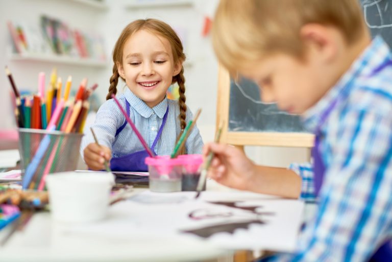 Early Years Education - Two kids painting in school