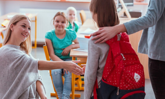 A teacher welcomes a new student in the class