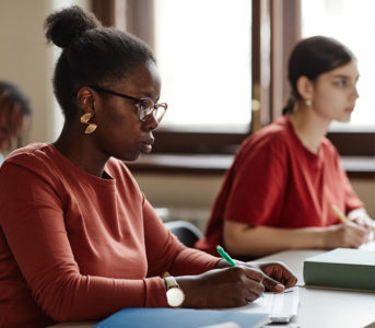 Two women taking notes