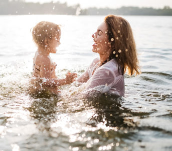 A mother plays with her daughter in the water