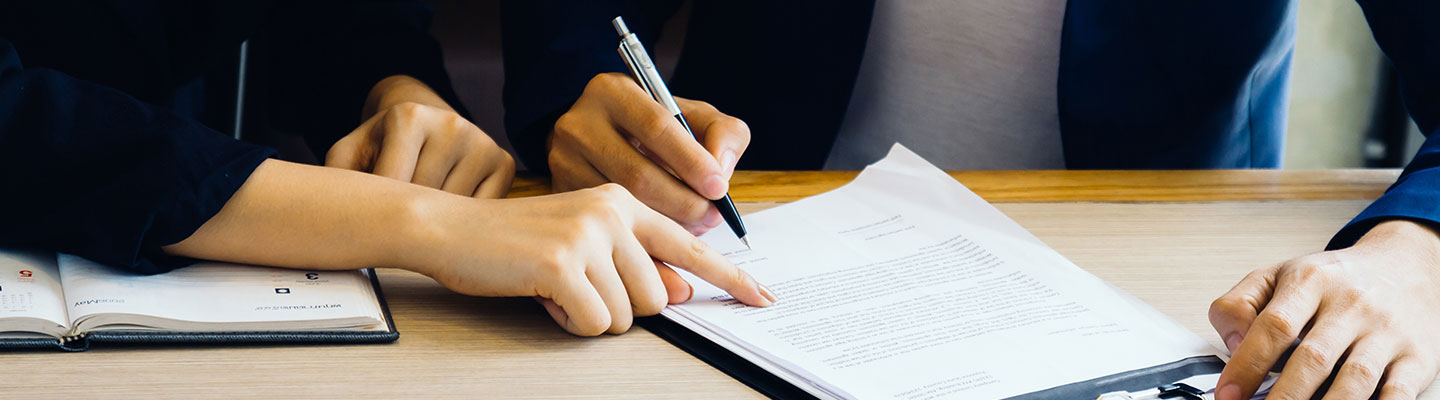 A lawyer making a man sign a document