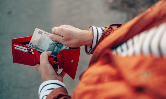 An older lady removing a fiver from her wallet