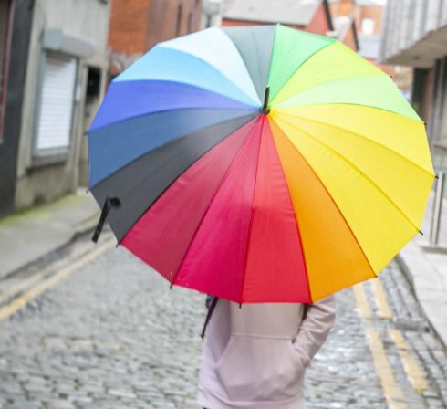 A person carrying a colorful umbrella