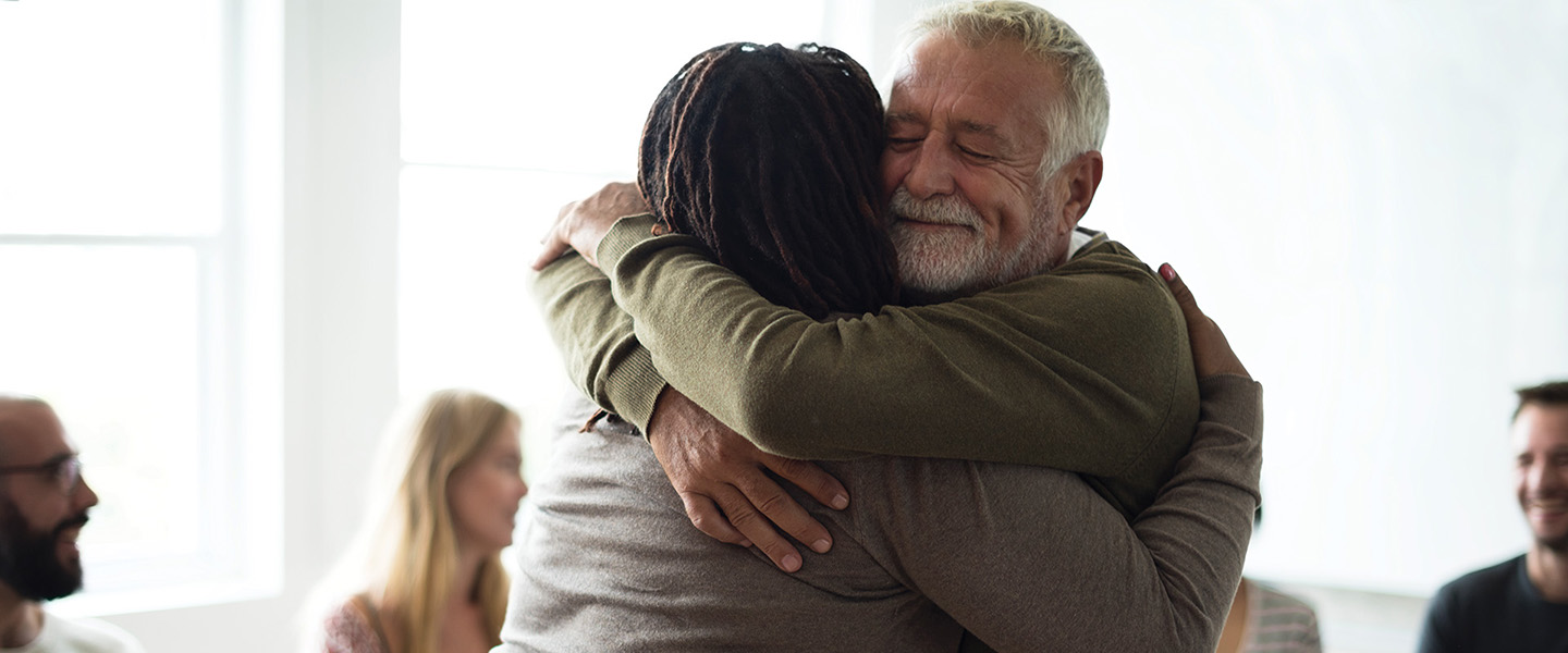 A man hugging a woman in a support group