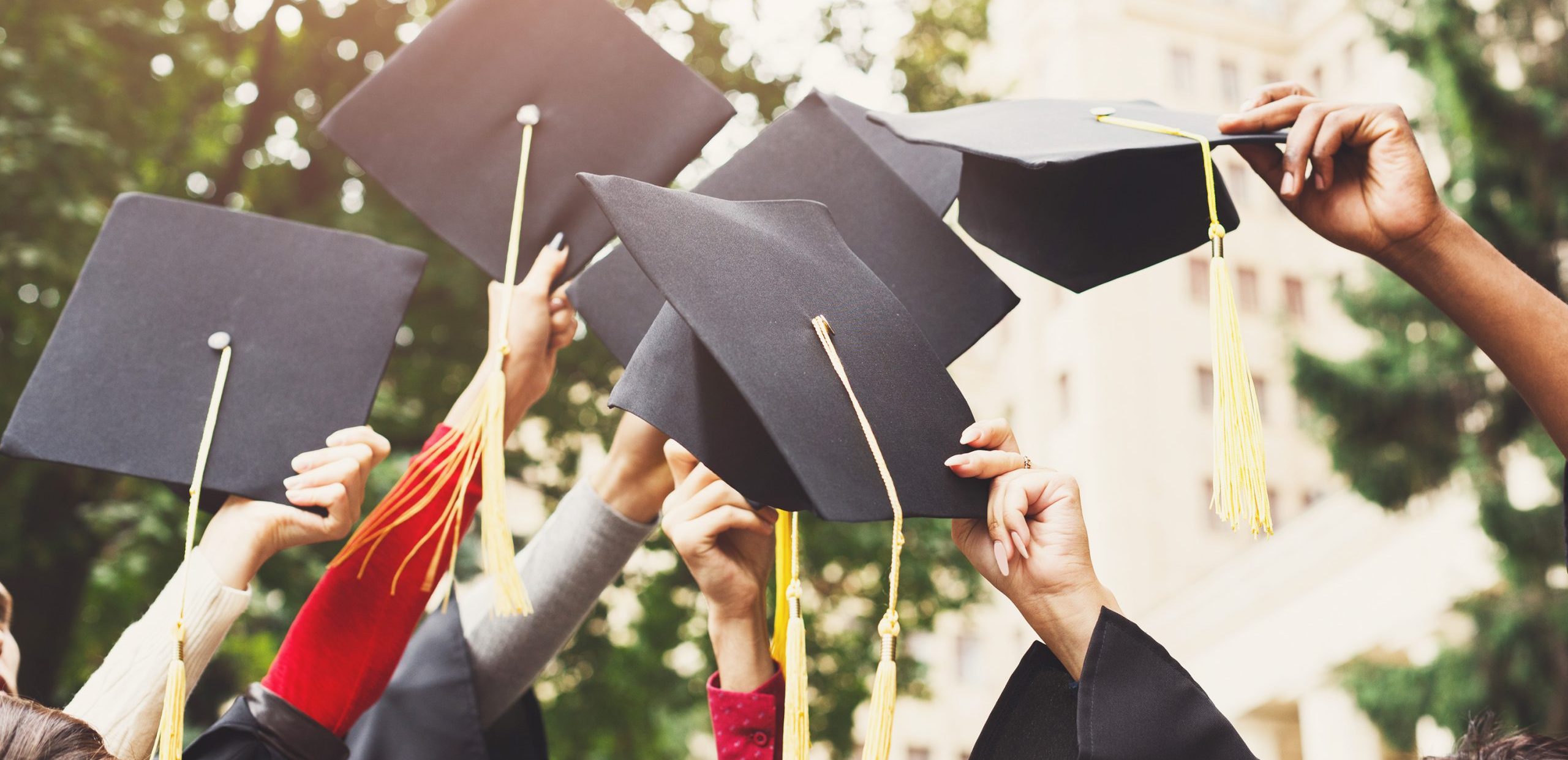 A group of graduates throwing graduation caps in the air