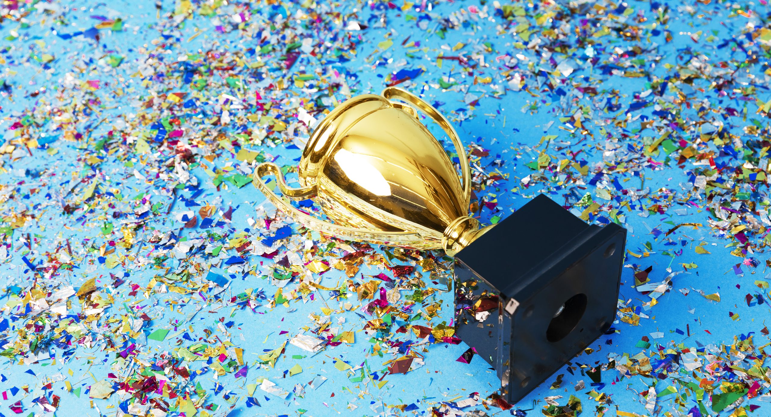 Gold trophy on a confetti background