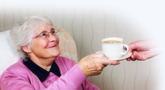 A sweet old woman being handed a coffee