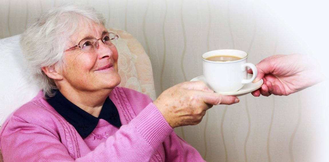 A sweet old woman being handed a coffee