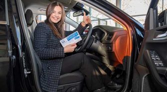 Woman sitting in car holding a raffle ticket