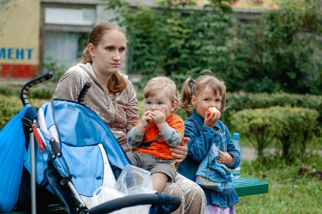 a-young-mother-and-her-two-children-are-walking-on