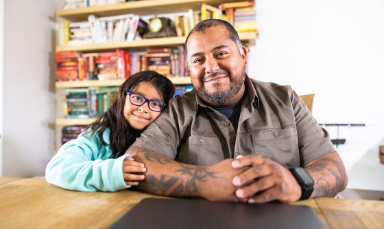 A Hispanic American veteran double amputee on a laptop