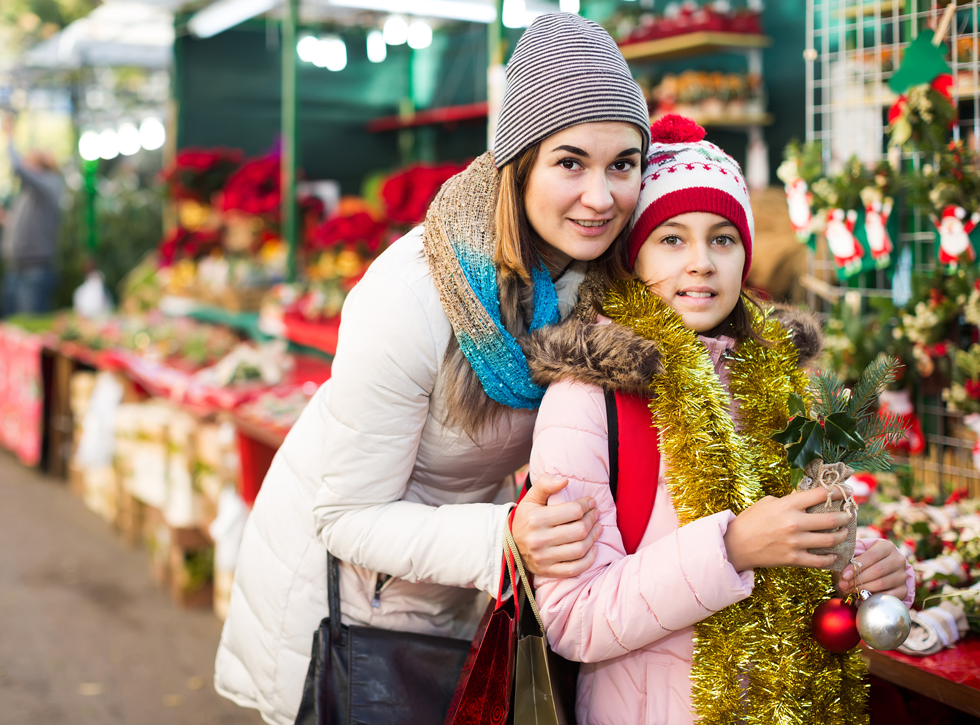 Impact Stories - happy european woman with daughter looking at floral decoration at Cristmas fair